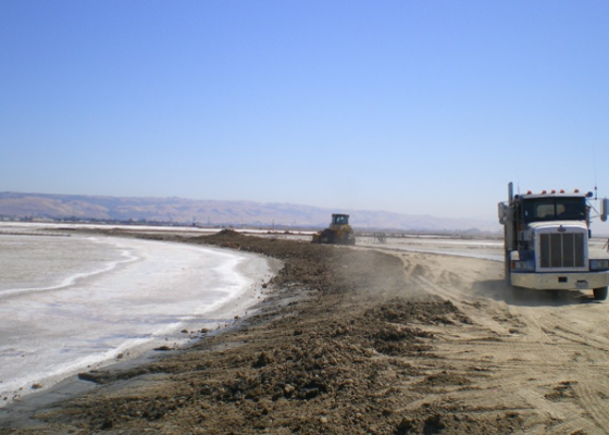 Large truck on the beach, working on the shoreline.